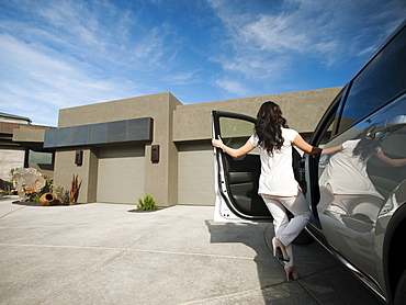 Young woman getting in car, USA, Utah, St. George