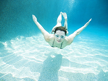 Young attractive woman diving in swimming pool