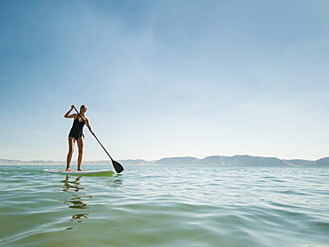 Young woman standing on paddleboard