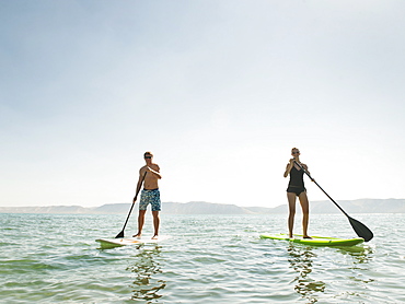 Two people standing on paddleboard