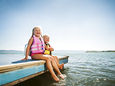 Girls (2-3, 4-5) sitting at the edge of raft in life jackets