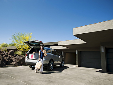 Woman with groceries leaving car, USA, Utah, St George