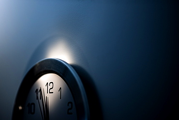 Close-up of wall clock with hands approaching midnight