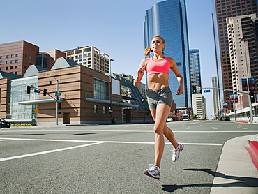 USA, California, Los Angeles, Young woman running on city street, USA, California, Los Angeles