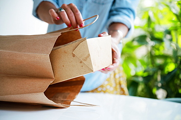 Close-up of woman unpacking take out food at home