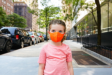 USA, New York, New York City, Portrait of girl (2-3) in face mask standing on sidewalk