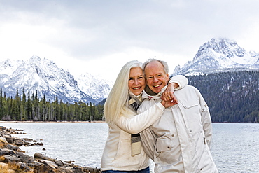 USA, Idaho, Stanley, Portrait of smiling senior couple at mountain lake