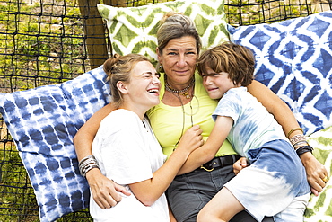 Mother with boy (8-9) and girl (16-17) in hammock