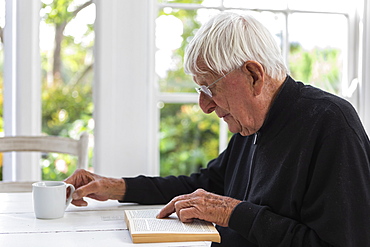 Senior man reading book at home