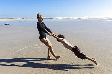 South Africa, Hermanus, Girl (16-17) and boy (8-9) playing on Grotto Beach