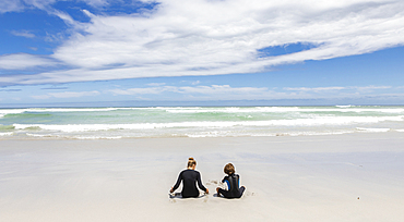 Girl (16-17) and boy (8-9) with body boards on Grotto Beach