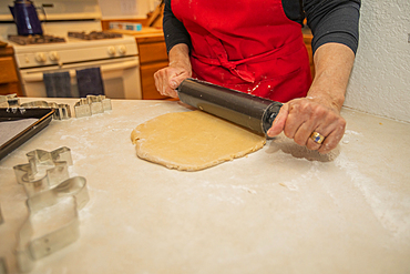 Woman baking Christmas cookies in kitchen