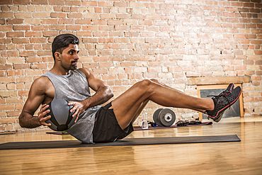 Man exercising with medicine ball in gym