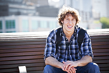 USA, Washington, Seattle, Young man sitting on bench