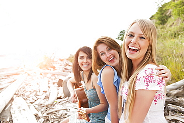 Portrait of young women with guitar on beach