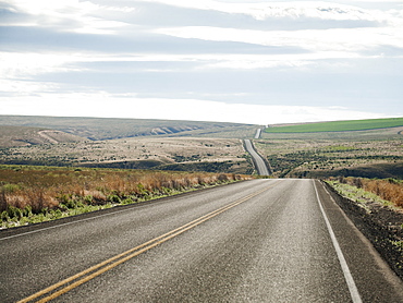 USA, Oregon, Boardman, Rolling landscape with empty road