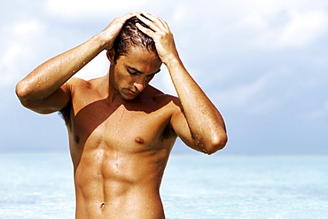 Handsome young guy standing in the sea