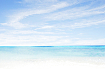 Wispy clouds above calm turquoise sea