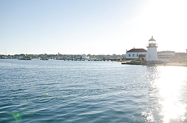 Brant Point Lighthouse and harbor with water reflecting sunlight