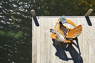 Overhead view of adirondack chair with book and blanket on pier on Lake Placid