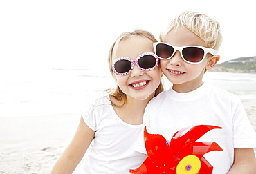 Portrait of brother (4-5) and sister (10-11) wearing sunglasses on beach