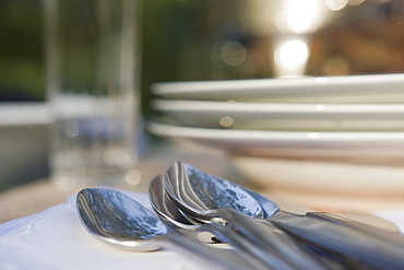 Close-up of cutlery and plates on dinner table