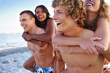 Young men carrying girlfriends on backs