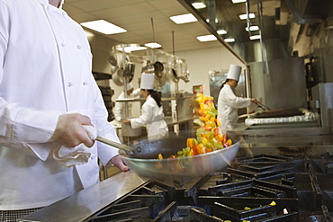 Chef tossing food in skillet