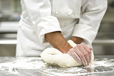 Baker kneading bread dough