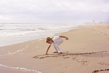 Girl drawing in sand