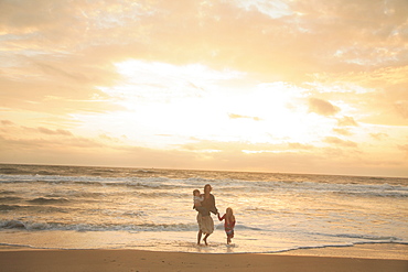 Mother and children walking on beach