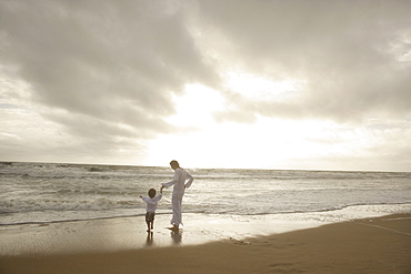 Mother and child holding hands at beach