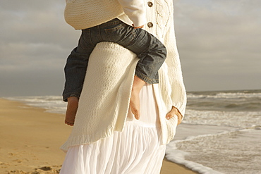 Mother holding child at beach