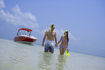 Couple with snorkeling gear walking in water, Florida, United States