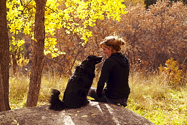 Woman and her collie sitting on stone, Colorado, USA