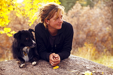 Woman and her collie leaning on rock, Colorado, USA