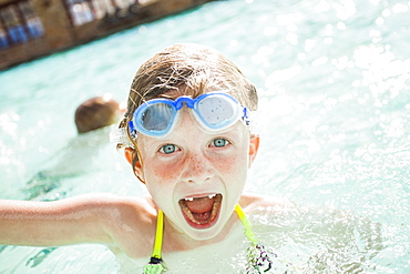 Girl and boy (4-5) playing in swimming pool