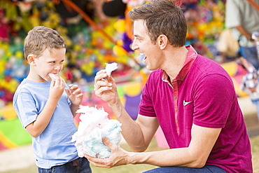 Happy father with son (4-5) in amusement park eating cotton candy, USA, Utah, Salt Lake City 