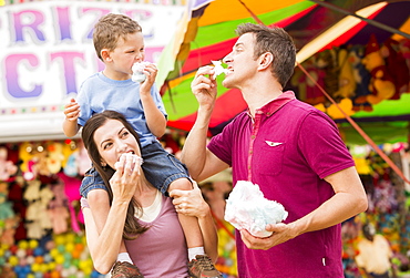 Happy family with son (4-5) in amusement park eating cotton candy, USA, Utah, Salt Lake City 