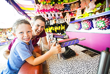 Father with son (4-5) playing with water gun in amusement park, USA, Utah, Salt Lake City 