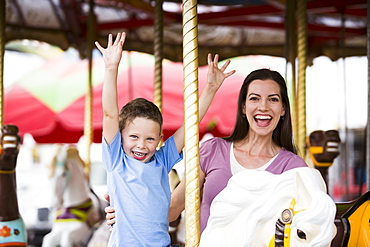 Mother and son (4-5) on carousel in amusement park, USA, Utah, Salt Lake City 