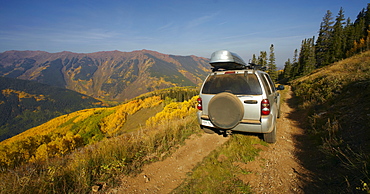 Mountain landscape with car on dirt road, Western Colorado