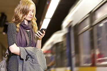 USA, California, Los Angeles, Woman sending text messages on subway station