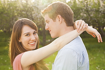 Young couple embracing in orchard