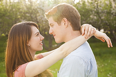 Young couple embracing in orchard