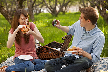 USA, Utah, Provo, Young couple having picnic in orchard