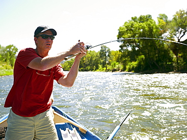 USA, Colorado, Man fly-fishing from boat