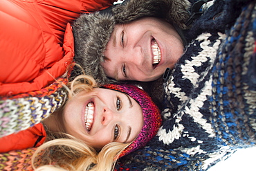 Portrait of young couple lying in snow