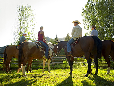 USA, Colorado, Family with teenage boy (14-15) riding horses on ranch