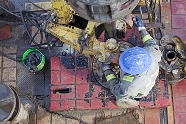 Oil worker drilling for oil on rig